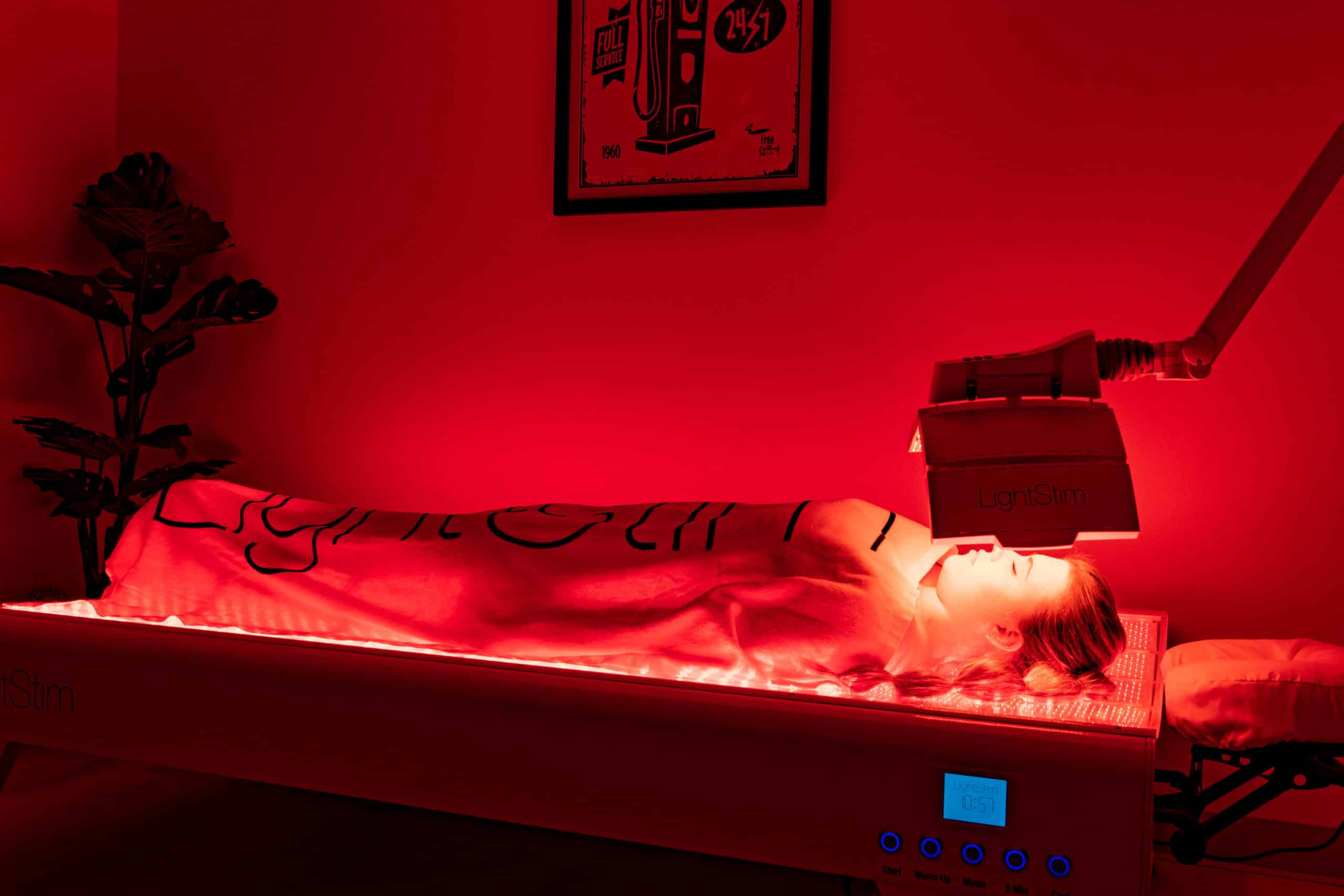 LightStim Bed Woman on Light Stim bed for red-light therapy at Ascent Adaptation and Regeneration